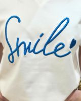 T-shirt femme écru broderie Smile bleue col V